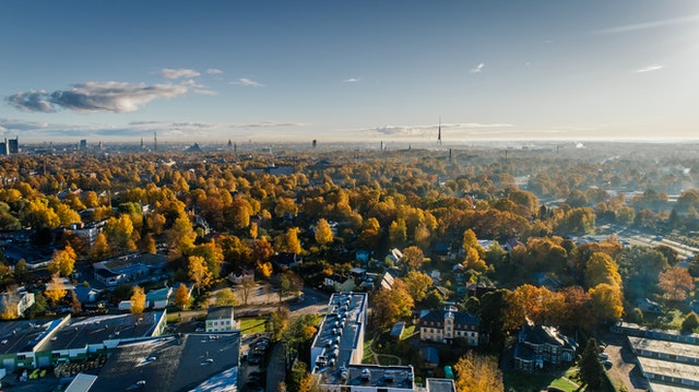 Aerial view of a vibrant autumn landscape in Maryland, showcasing colorful trees and residential areas, relevant to custom home building and local insights.