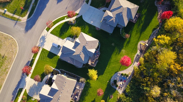 Aerial view of suburban Maryland homes with landscaped yards and colorful autumn trees, illustrating residential community features relevant to custom home building.