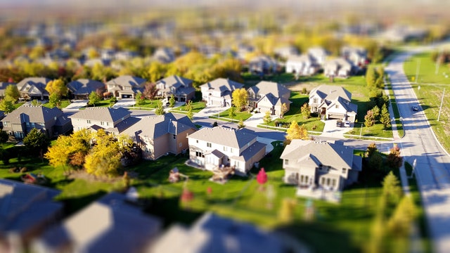 Aerial view of a suburban neighborhood featuring custom homes with landscaped yards, showcasing residential architecture relevant to Maryland home buyers.