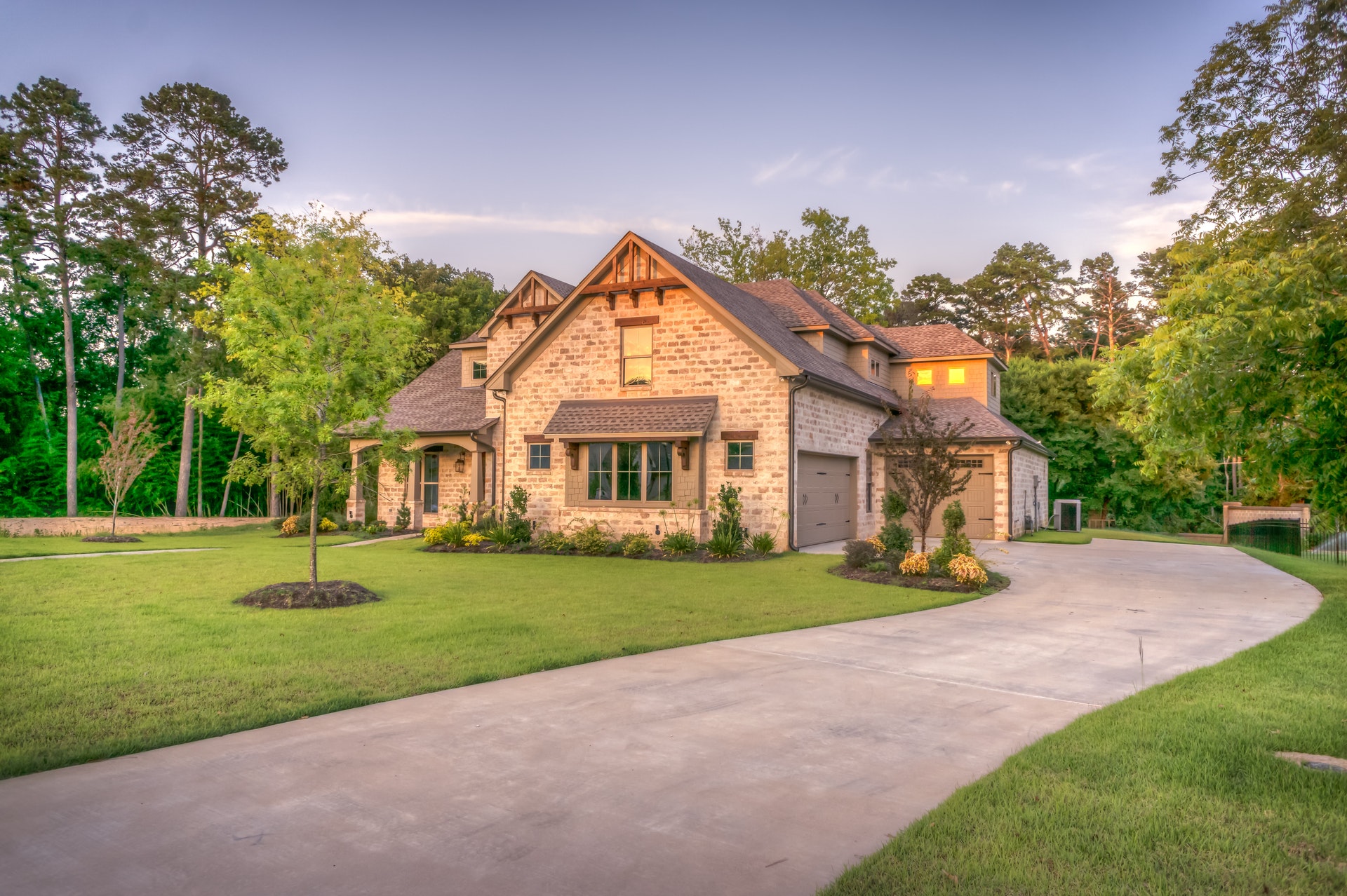Custom Maryland home featuring a stone exterior, landscaped yard, and driveway, highlighting quality construction and design by Woodbridge Homes.